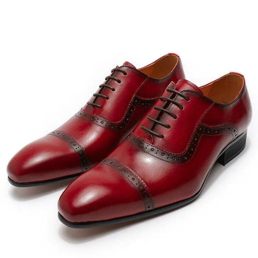 Men's red leather dress shoes with pointed toe and brown brogue detailing on white background