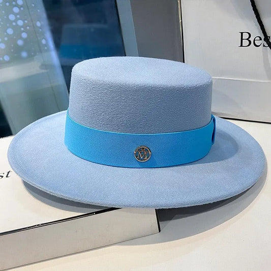 Elegant light blue flat top fedora hat for women with a blue band and metallic logo accent