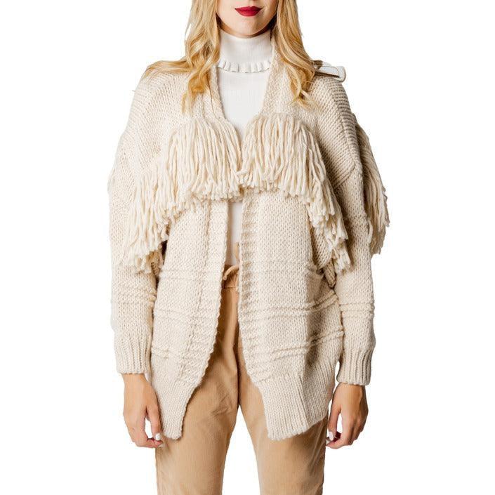 Woman wearing a chunky beige knit cardigan with fringe, Hanny Deep collection fashion