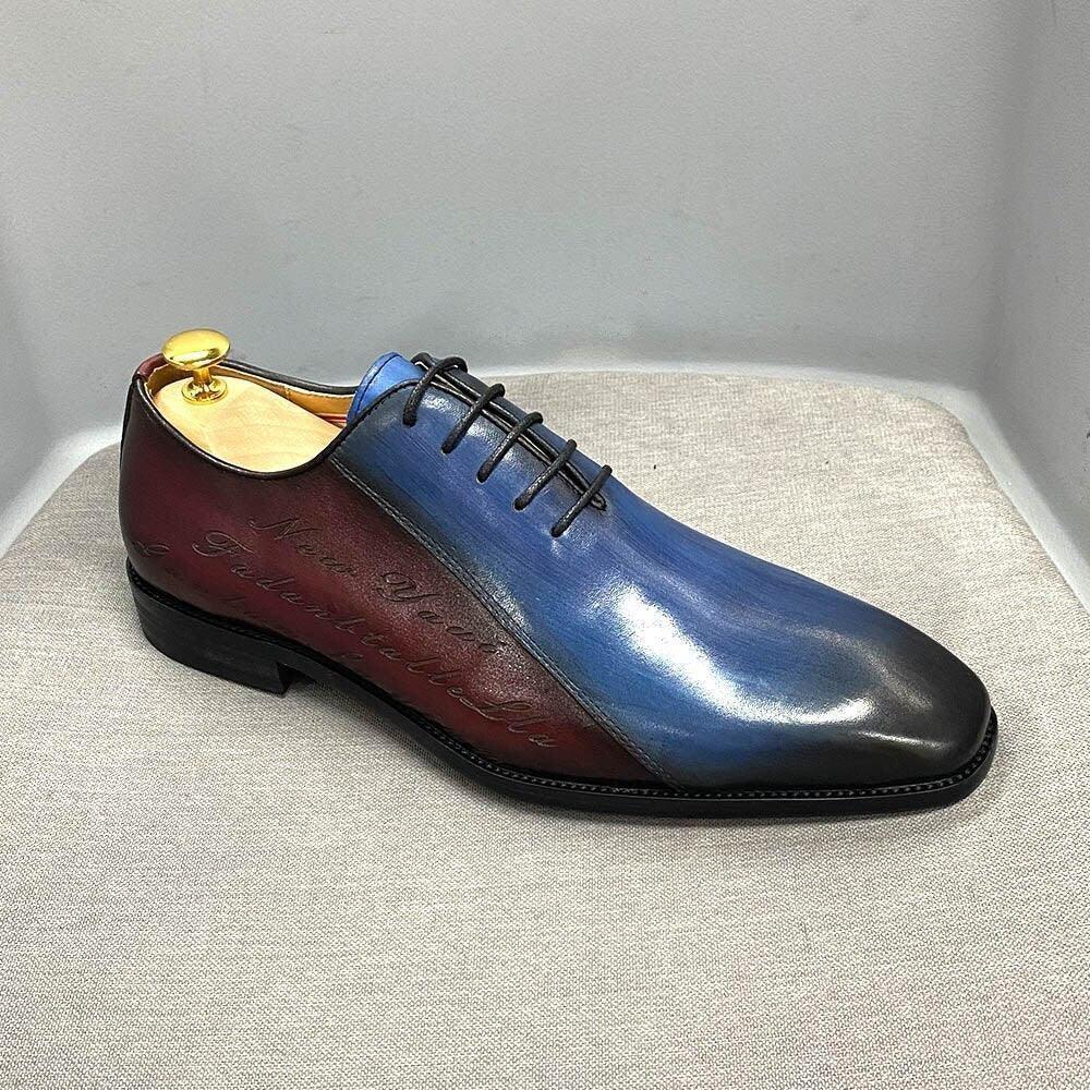 Two-tone men's dress shoe with blue and burgundy leather, black laces, on display
