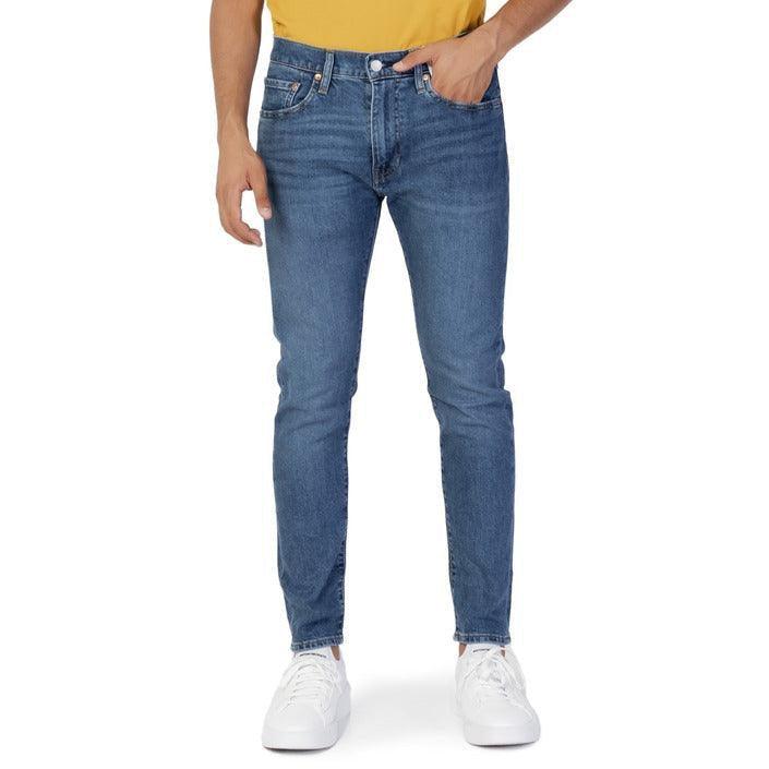 Men's blue jeans styled with white sneakers and a yellow shirt