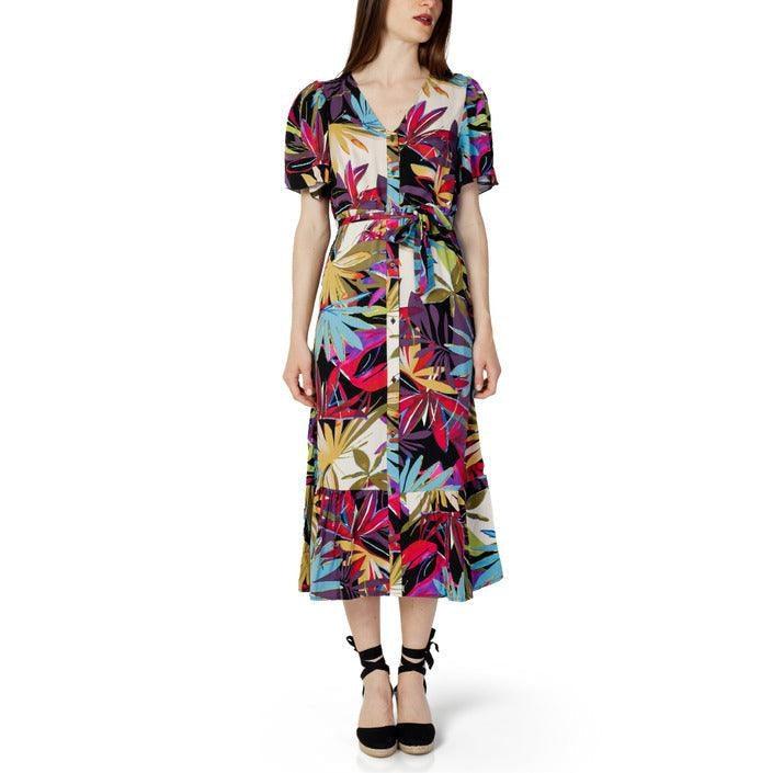 Woman wearing a colorful tropical leaf print midi dress with short sleeves and belt