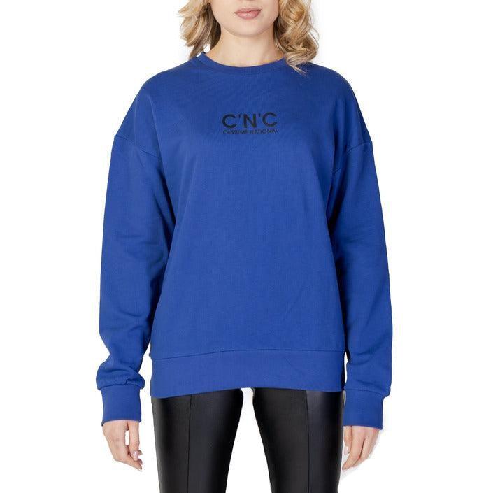 Woman wearing a blue C'N'C sweatshirt and black leather pants on white background