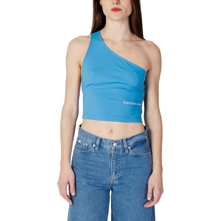 Woman wearing a blue one-shoulder tank top and high-waisted blue jeans