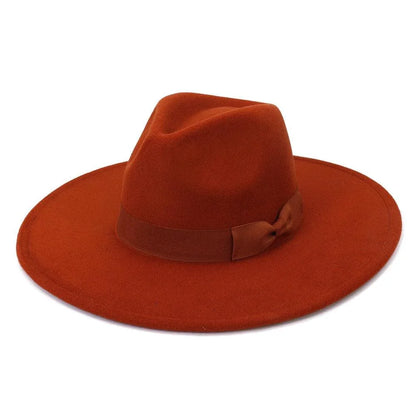 Wide brim retro fedora hat in burnt orange with ribbon detail on a white background.