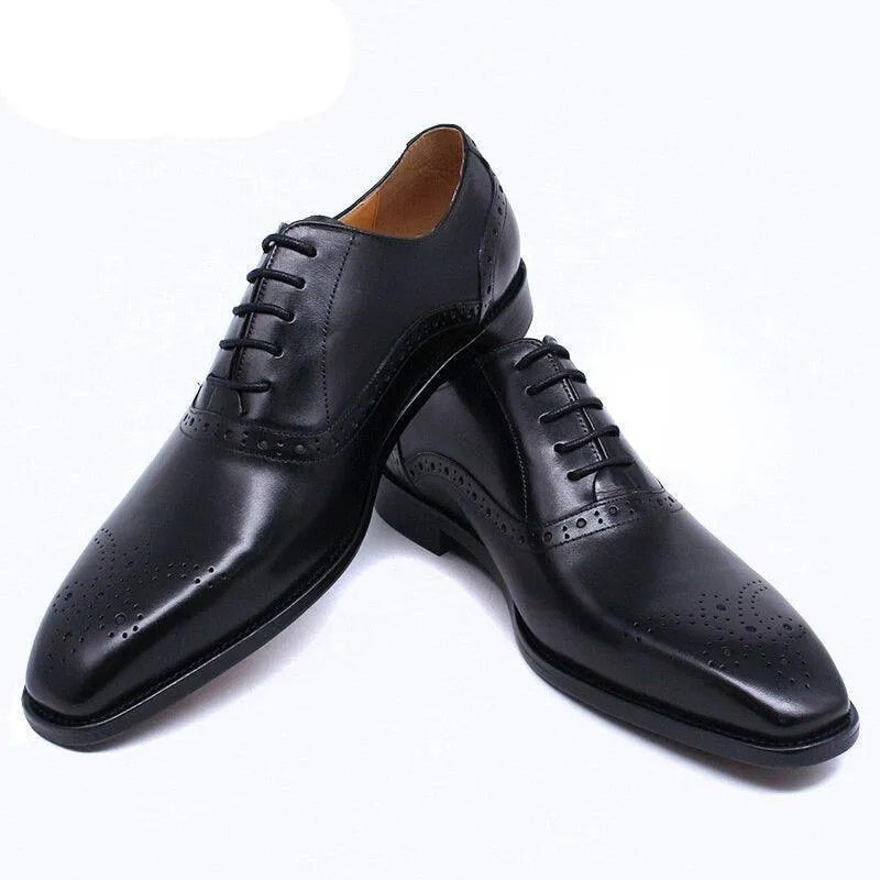 Black leather lace-up dress shoes for men with brogue details on white background.