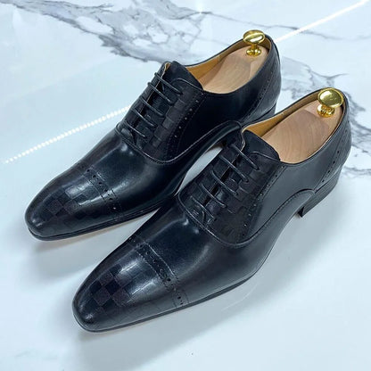 Black leather lace-up men's dress shoes with subtle check pattern on a marble surface