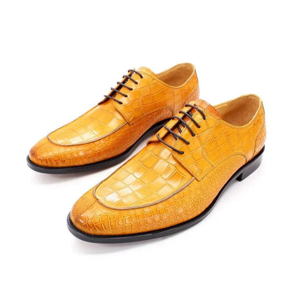 Men's tan crocodile-patterned dress shoes with black soles on white background