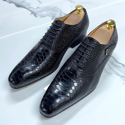 Black snakeskin pattern men's dress shoes on marble surface