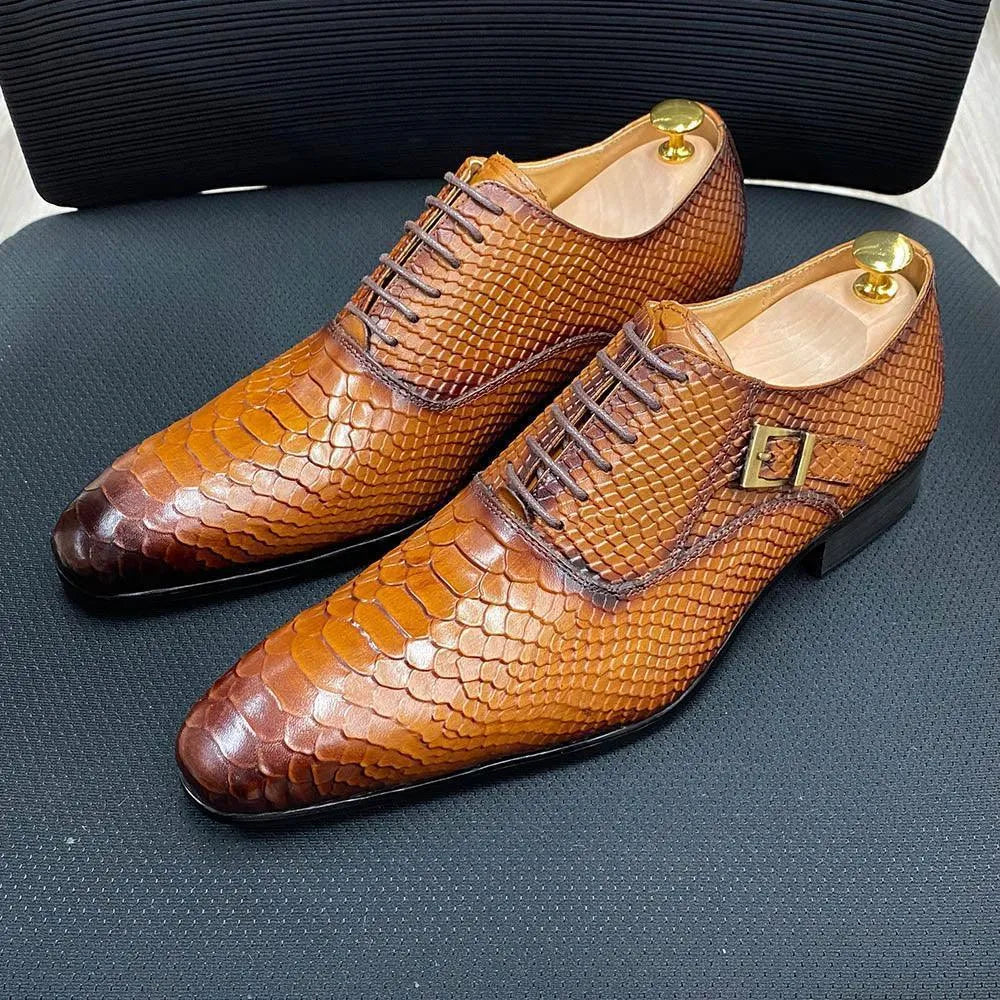 Brown python leather men's dress shoes with lace-up and buckle, displayed on a chair