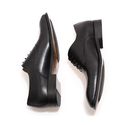 Black classic leather men's dress shoes with closed lacing on white background