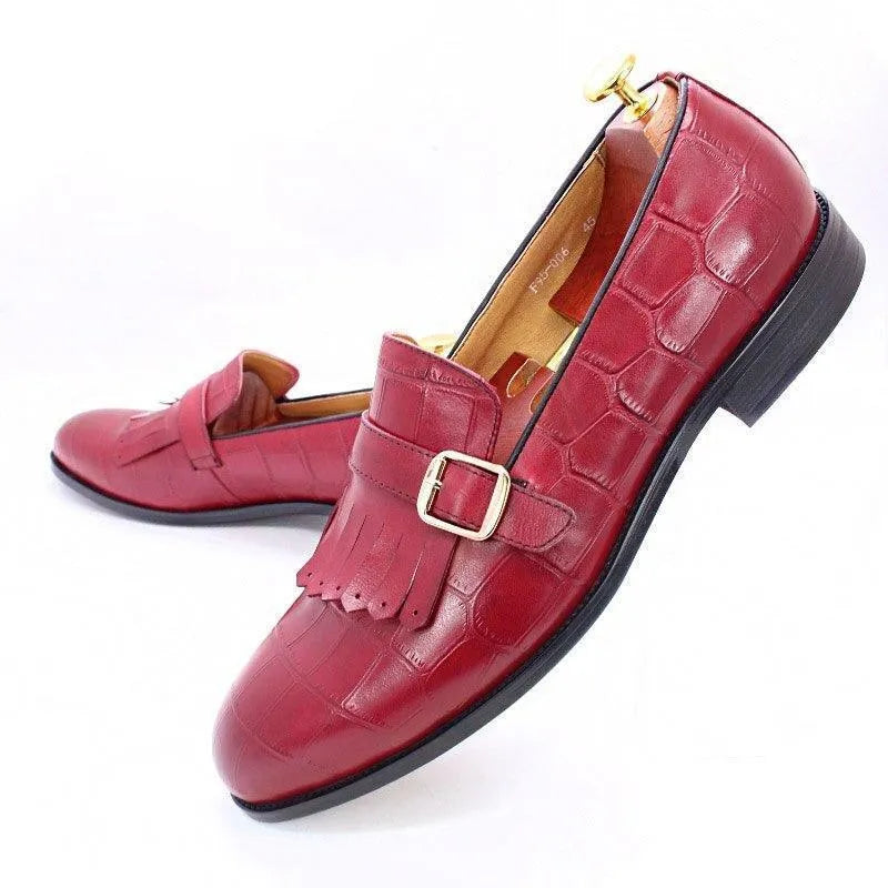 Red men's dress shoes with buckle, fringe detail, and crocodile pattern on white background