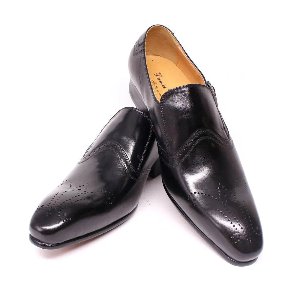 Black leather pointed toe men's dress shoes with brogue detailing on white background