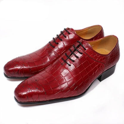 Glossy red crocodile pattern men's dress shoes with black laces on a white background