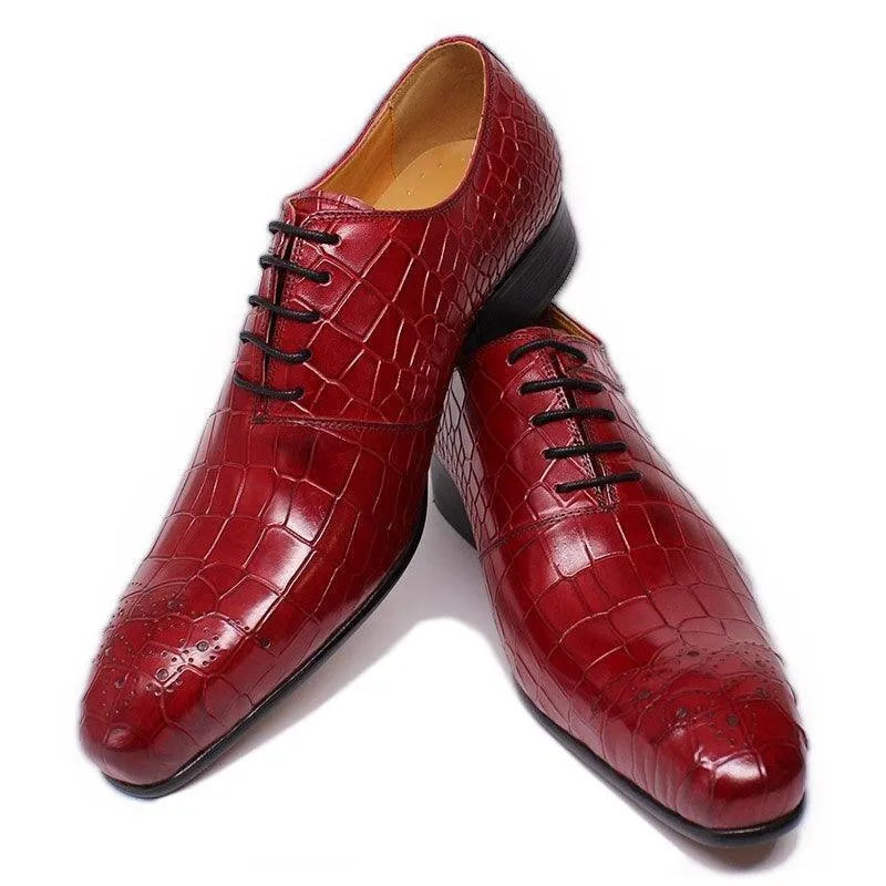 Burgundy crocodile pattern leather men's dress shoes with black laces on white background