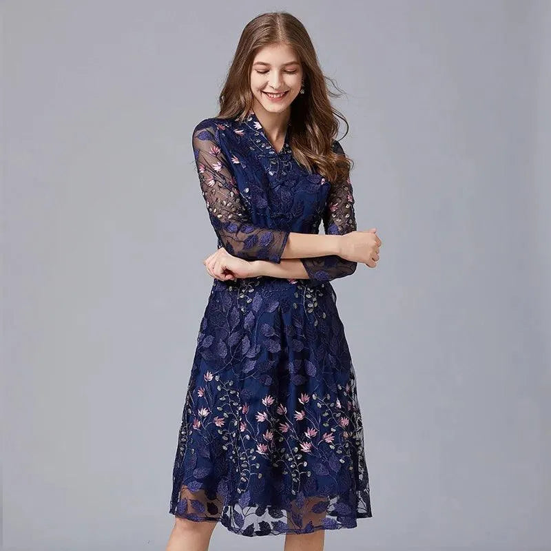 Model in a navy embroidered floral knee-length dress with sheer three-quarter sleeves fashion image