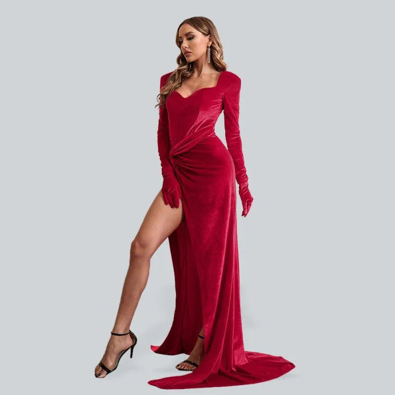 Woman wearing a red velvet long-sleeve evening dress with a high slit, fitted waist and floor-length hem for weddings, parties and formal evening occasions