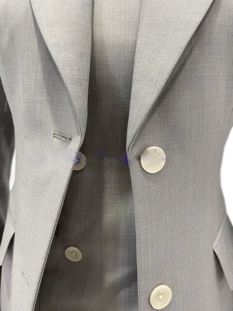 Grey 3-piece women's pantsuit with blazer and vest, close-up on buttons and fabric