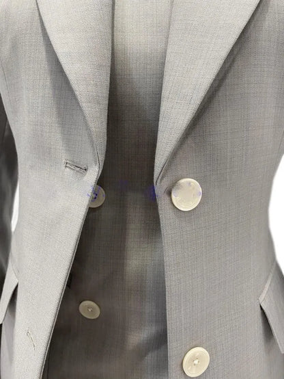 Grey 3-piece women's pantsuit with blazer and vest, close-up on buttons and fabric