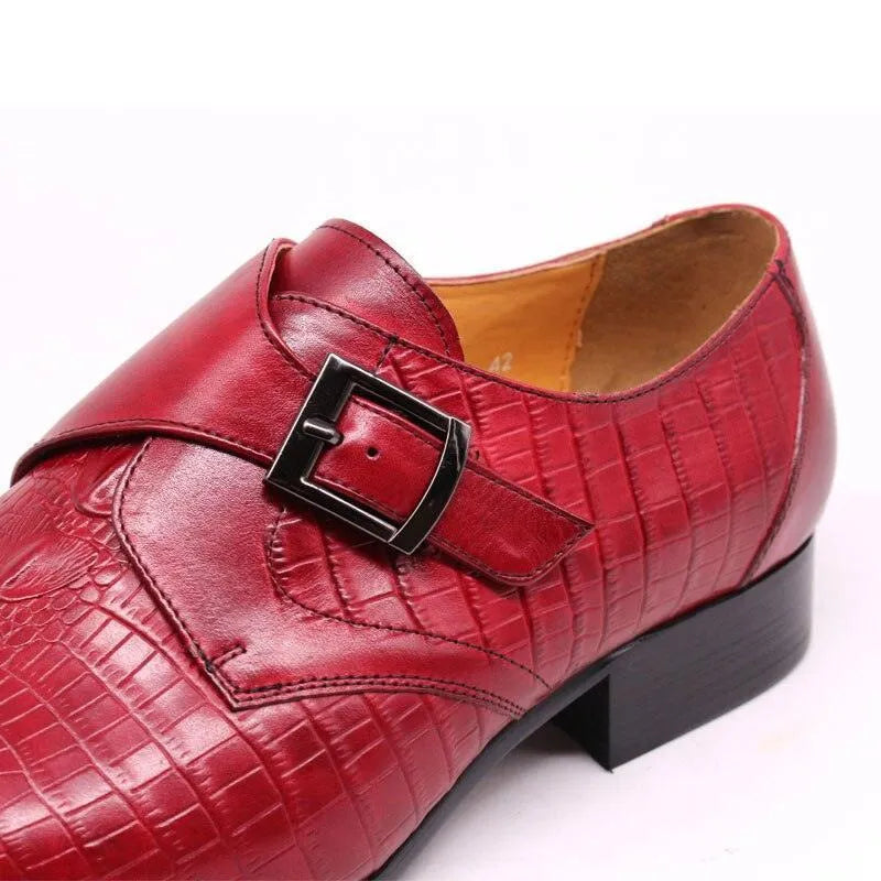 Red men's leather dress shoe with textured pattern and metal buckle on white background