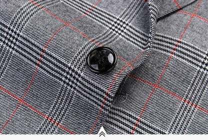 Close-up of plaid men's suit jacket fabric with button and red grid pattern