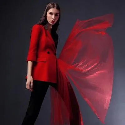 Woman wearing red and black pantsuit with detachable red veil, fashion photoshoot