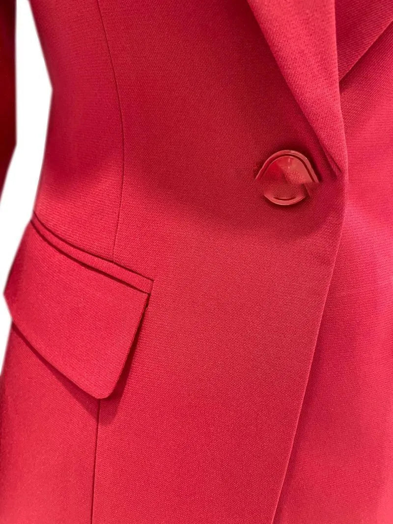 Close-up of a red women's business pantsuit with a single button and side pocket